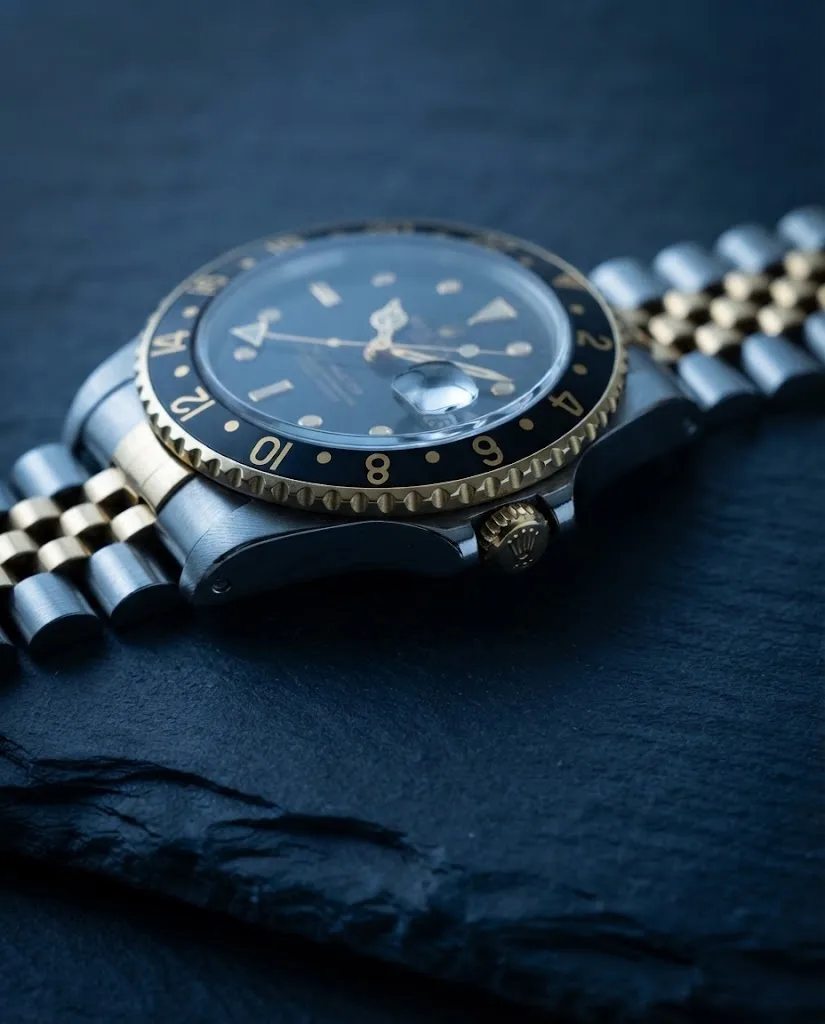 Illustrative render — reading the listing of the Rolex GMT-Master 40mm (steel and yellow gold, black dial, black bezel, Jubilee)