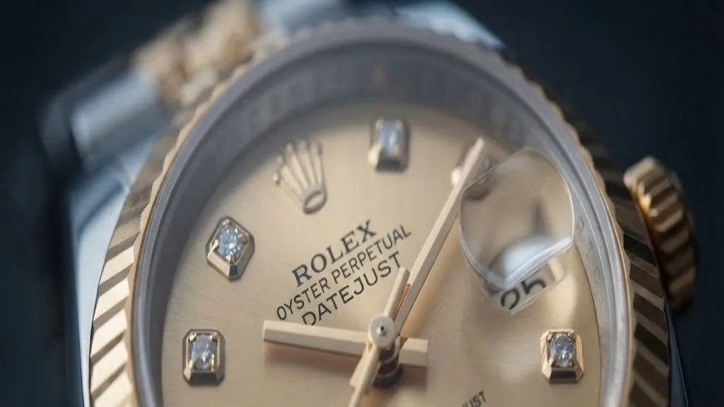 Illustrative render — diamonds, gold, and a dated card of the Rolex Lady-Datejust 26 (steel and 18k yellow gold, champagne diamond dial, fluted bezel, Jubilee bracelet, box and dated card, pre-owned)